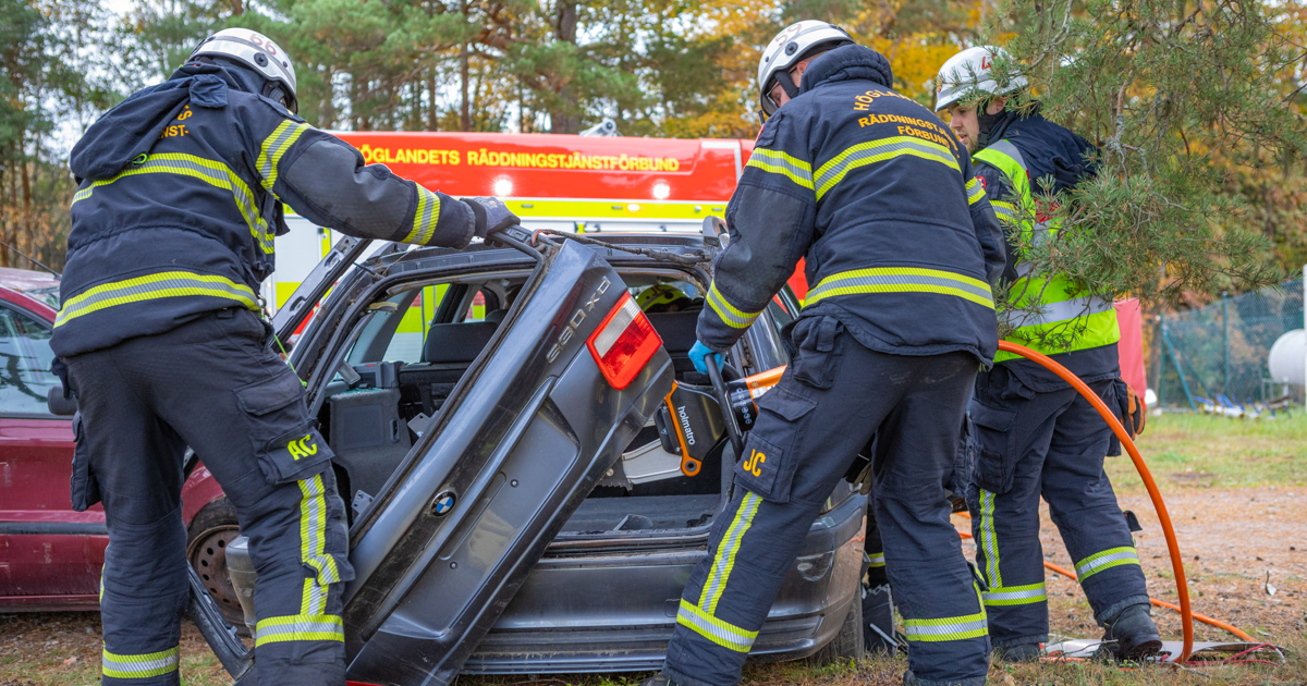 En grupp brandmän som arbetar med en bil.