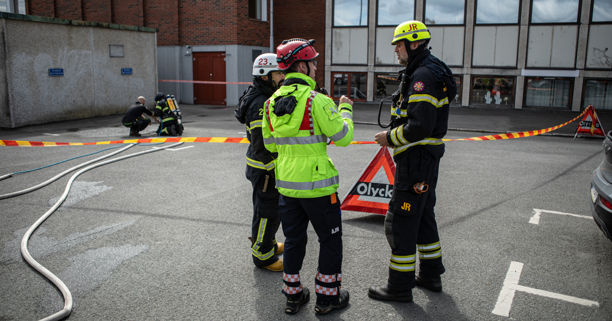 Några män som står bredvid varandra framför en byggnad.