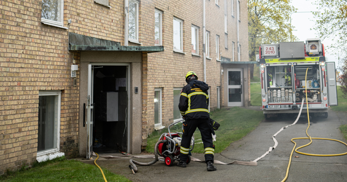 En brandman släcker en brand i en byggnad.