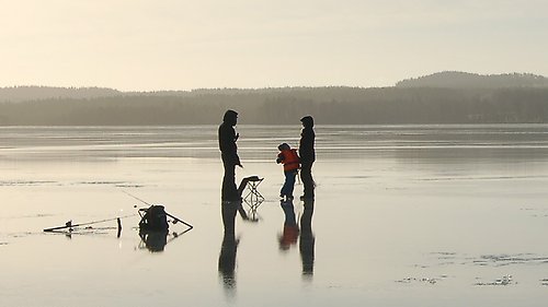 Människor fiskar på isen.